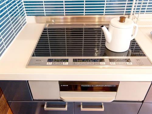 a stove top oven with a coffee mug on it at Tenkyu Inn - Vacation STAY 07349v in Kachabaru