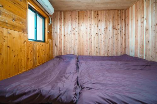 a bed in a wooden room with a window at Fukouji - Vacation STAY 07341v in Numata