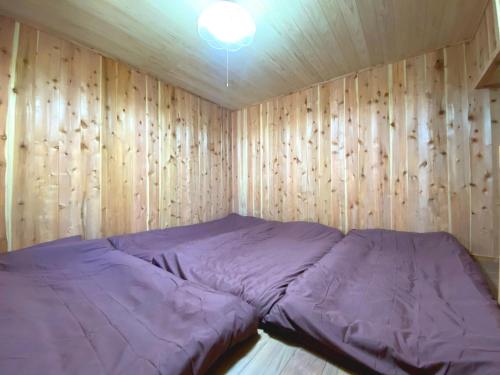 a bed in a room with a wooden wall at Fukouji - Vacation STAY 07341v in Numata
