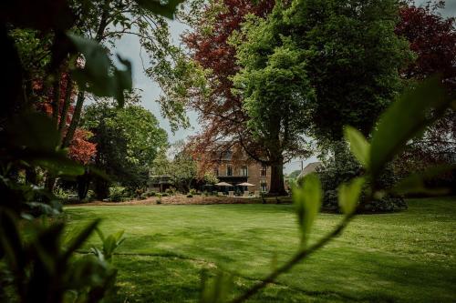 a house in the middle of a field with trees at Relais M in Frasnes-lez-Anvaing