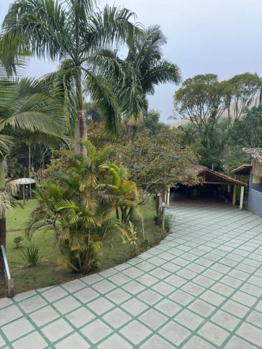 a resort with palm trees and a tile walkway at Pousada Toledo in Cunha