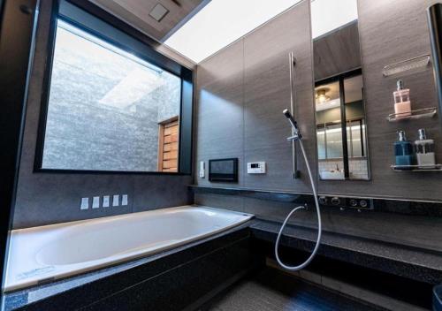 a bathroom with a tub and a large window at HAKATA TERRACE -hare- - Vacation STAY 12421 in Fukuoka