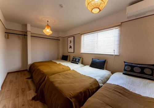 a room with four beds in it with a window at HAKATA TERRACE -hare- - Vacation STAY 12421 in Fukuoka