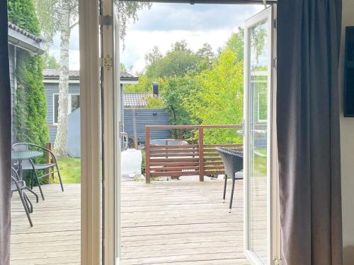 a sliding glass door leading to a deck with a bench at 6 person holiday home in GRÄNNA in Gränna