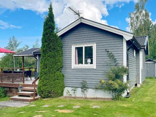a blue house with a porch and a yard at 6 person holiday home in GRÄNNA in Gränna