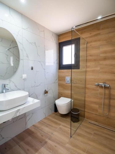 a bathroom with a toilet and a sink and a shower at Novus apartments in Skala Marion