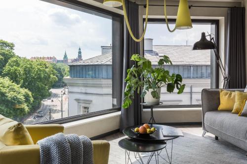 a living room with a couch and a large window at Modern View of Planty Park in Kraków