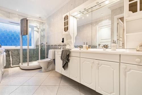 un bagno bianco con vasca e lavandino di Fjordside Escape - Spacious apartment with amazing views a Tysnes