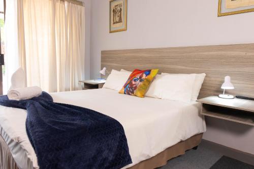 a bedroom with a large white bed with a woman pillow at Gorgeous Gecko Guesthouse in Modimolle