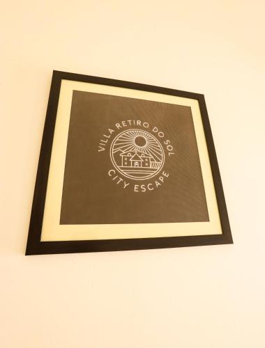 a framed picture of a sign on a wall at Peaceful Escape in Gurgaon - Villa Retiro Do Sol in Manesar