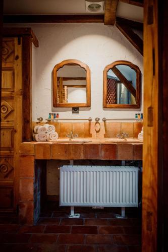 a bathroom with two sinks and two mirrors at Relais M in Frasnes-lez-Anvaing