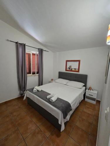 a bedroom with a large bed in a room at Apartmani Nika in Tribunj