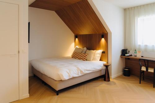 a bedroom with a large bed with a wooden headboard at Door9 Hasselt - Digital Hotel in Hasselt