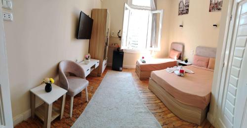a small bedroom with a bed and a couch at Tahrir Palace in Cairo