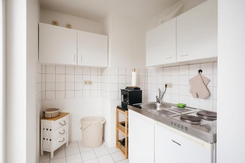 a white kitchen with a sink and a microwave at Comfort Apartment Leipzig in Leipzig