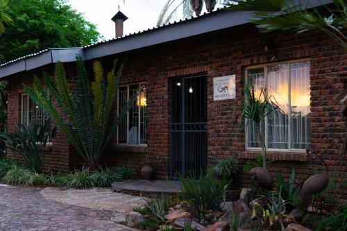 a brick building with a door and a window at Gorgeous Gecko Guesthouse in Modimolle