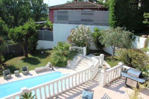 un cortile con piscina e una recinzione bianca di La Maisonnette du Clos a La Roquette-sur-Siagne