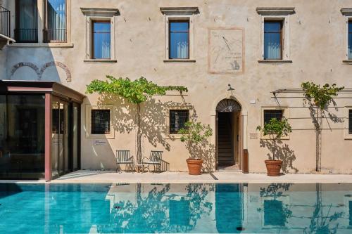 a house with a swimming pool in front of a building at Corte Regia Relais & Spa in Valeggio sul Mincio
