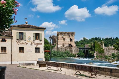 a building with a fountain and a building with a castle at Corte Regia Relais & Spa in Valeggio sul Mincio