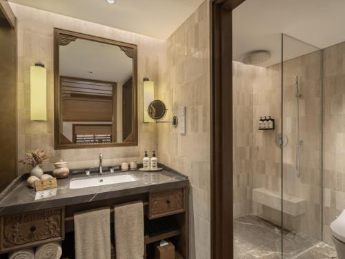 a bathroom with a sink and a shower at Paradisus by Meliá Bali in Nusa Dua