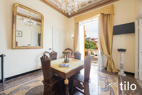 a dining room with a table and a mirror at Villa Aranci | Historical Residence | By Tilo Lux in Genova