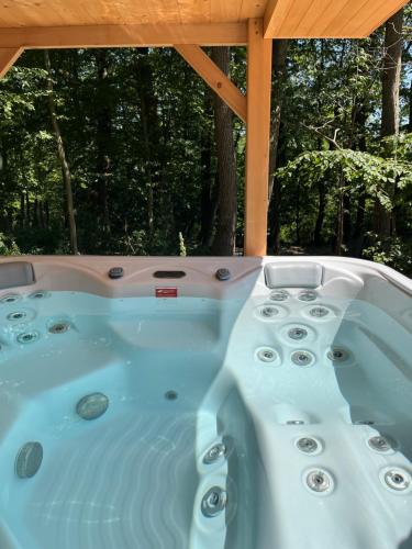 a hot tub sitting under a gazebo at Oaklounge Apartman in Kismaros