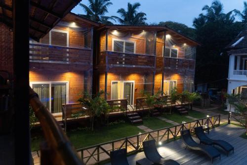 a building with tables and chairs in front of it at Tranquillo By The Beach in Candolim