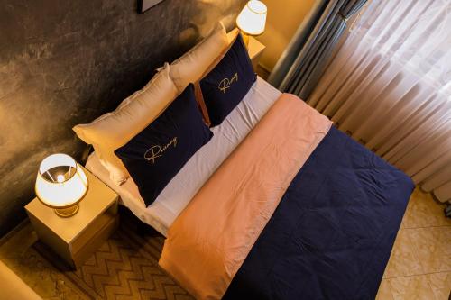 a bedroom with a bed with blue and orange pillows at Pitta Opulent Apartments in Kampala