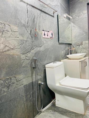 a bathroom with a white toilet and a shower at Cool breeze view Homestay in Madikeri