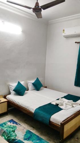 a bedroom with a bed with blue pillows on it at Hotel DRS by Vihasta, Balaghat 