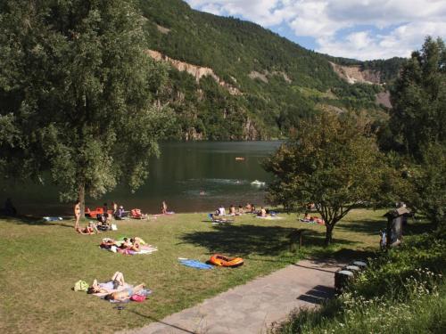 a group of people laying on the grass near a lake at Maison 40 in Albiano