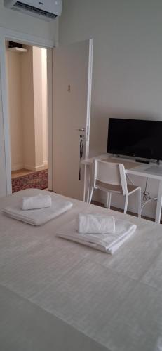 two beds in a room with a table and chairs at Affittacamere Risorgimento in Lecco