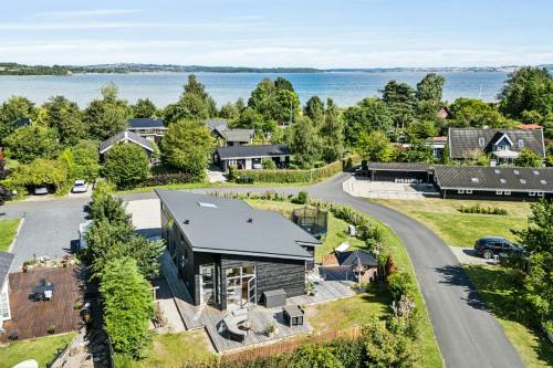 an aerial view of a house with a road and a lake at Cabin By Forest And Beach In Havhusene in Hornslet