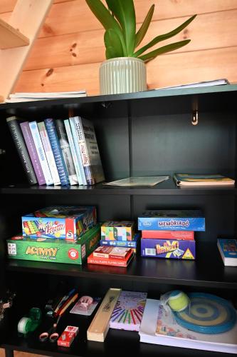 a book shelf filled with books and a potted plant at Oaklounge Apartman in Kismaros