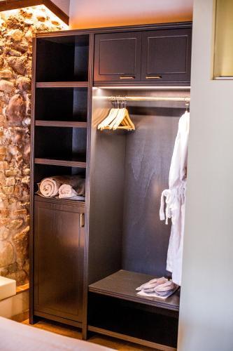 a walk in closet with wooden cabinets and towels at Corte Regia Relais & Spa in Valeggio sul Mincio