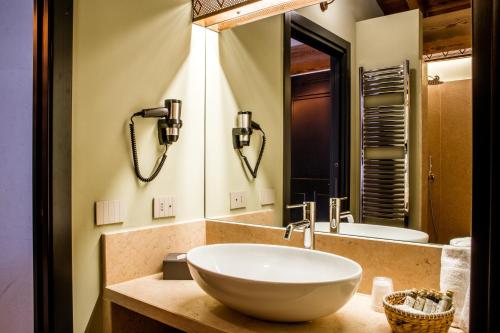 a bathroom with a white bowl sink and a mirror at Corte Regia Relais & Spa in Valeggio sul Mincio