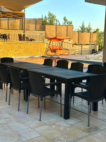 a large black table with chairs and a golf cart at sama vailla in Amman