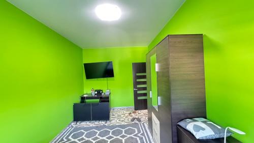 a green room with a bunk bed and a television at Modern apartment in Dnipro