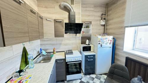 a kitchen with a stove and a refrigerator at Modern apartment in Dnipro