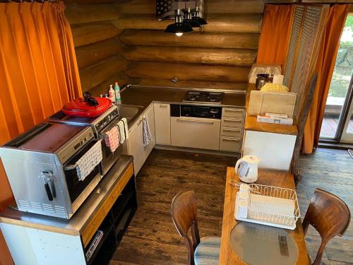 a kitchen with a stove and a table with chairs at BAY MARINA Loghouse - Vacation STAY 09656v in Sakaide