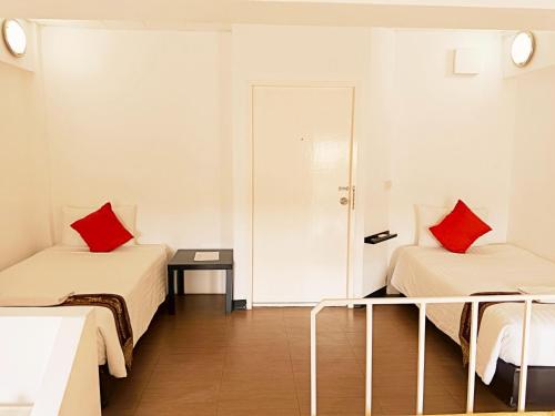 a room with two beds with red pillows at Siam Villa Suvarnabhumi in Ban Khlong Si