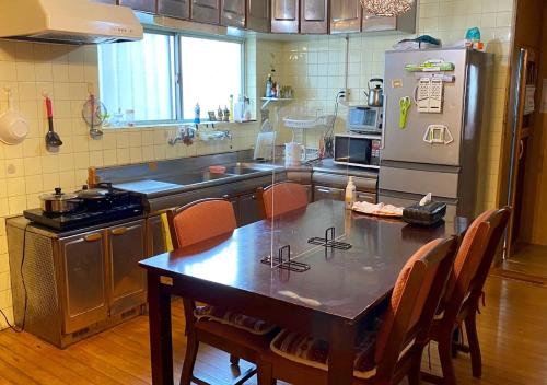 a kitchen with a table and a refrigerator at Guest house Icyaribacyoude - Vacation STAY 09894v in Naha