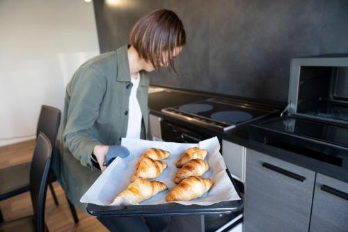 a woman holding a tray of loaves of bread at Awaji-shima Marine View - Vacation STAY 11199v in Minamiawaji