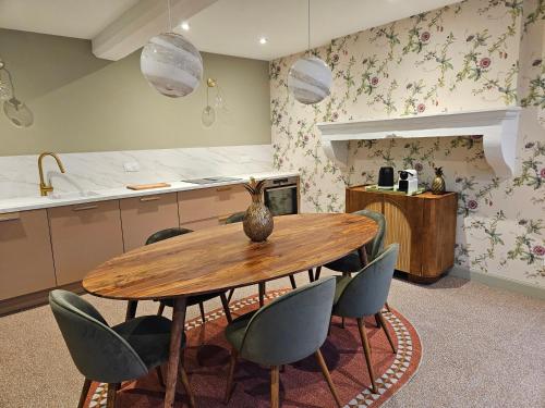 a kitchen with a wooden table and chairs at La Maison des Chouettes in Maisons-lès-Chaource