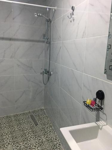 a shower with a glass door and a sink in a bathroom at Bella Casetta Guest House in Mağusa