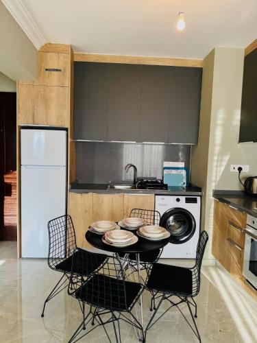 a kitchen with a table with chairs and a stove at Royal Sun Elite Daire in Aglantzia