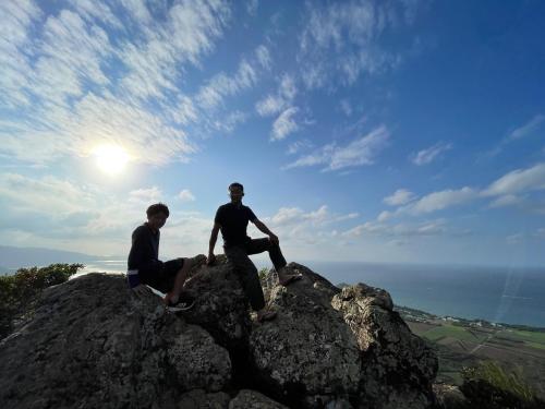 two men sitting on top of a rock at RAINBOW FOREST Permaculture filed - Vacation STAY 13693v in Ibaruma