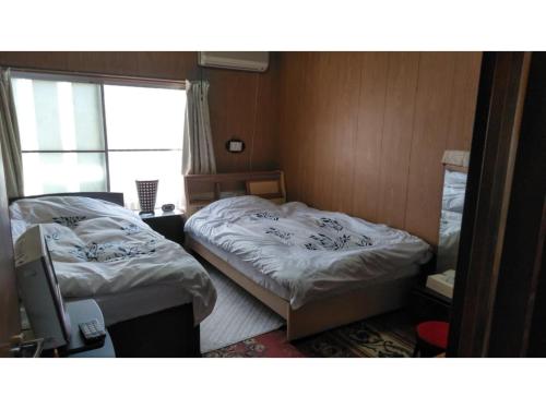 two beds in a small room with a window at Guesthouse Farmor - Vacation STAY 15083v in Imabari