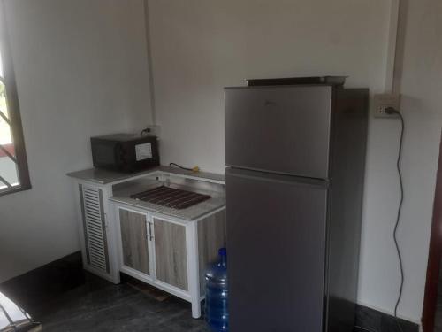 una piccola cucina con frigorifero e forno a microonde di Maison neuve et moderne à Vientiane 