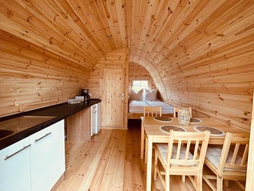 a kitchen and dining room with a table in a log cabin at Pod 89 in Hüde